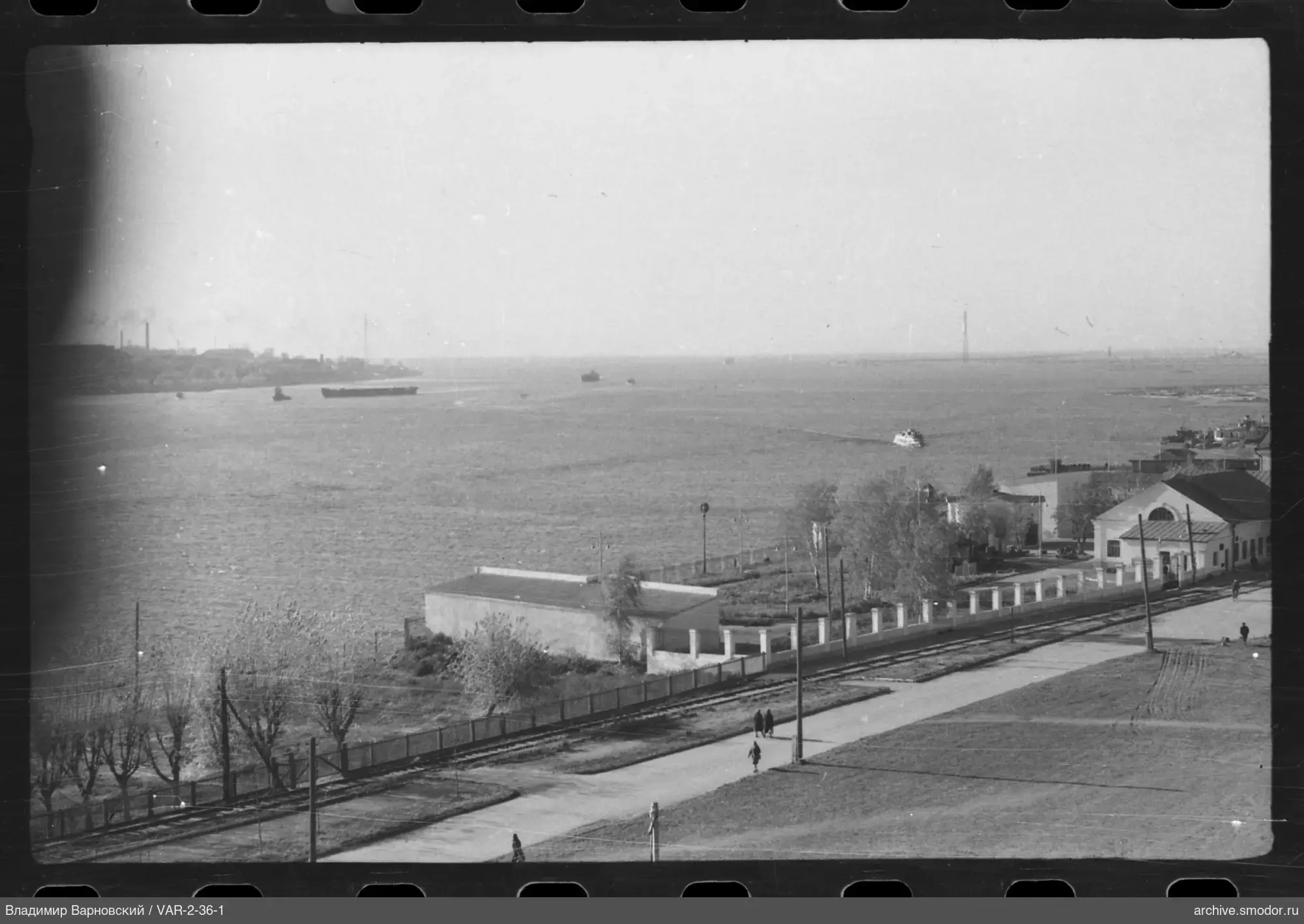 Breiter Fluss mit Schiffen und Uferpromenade