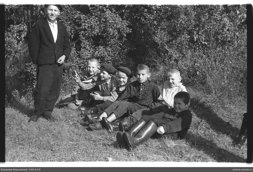 Gruppe von Jungen auf Gras bei Büschen