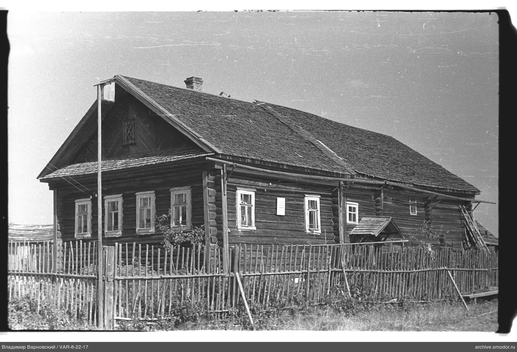 Wooden house with fence and plaque