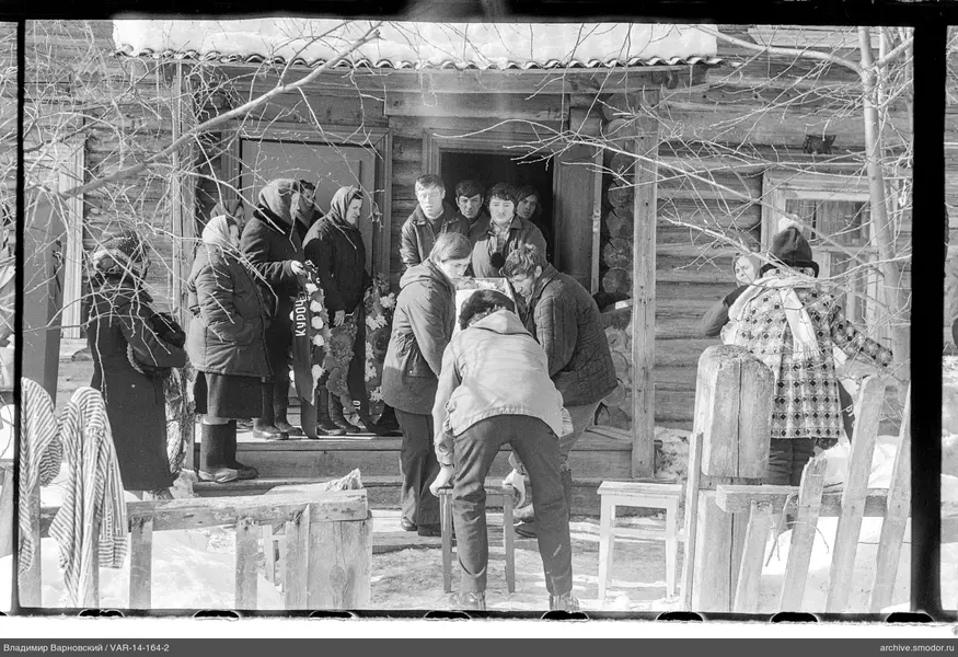 Мужчины несут гроб с венками