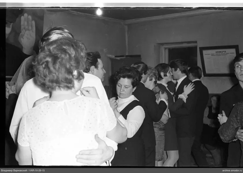 Couples dancing in a low-ceiling room