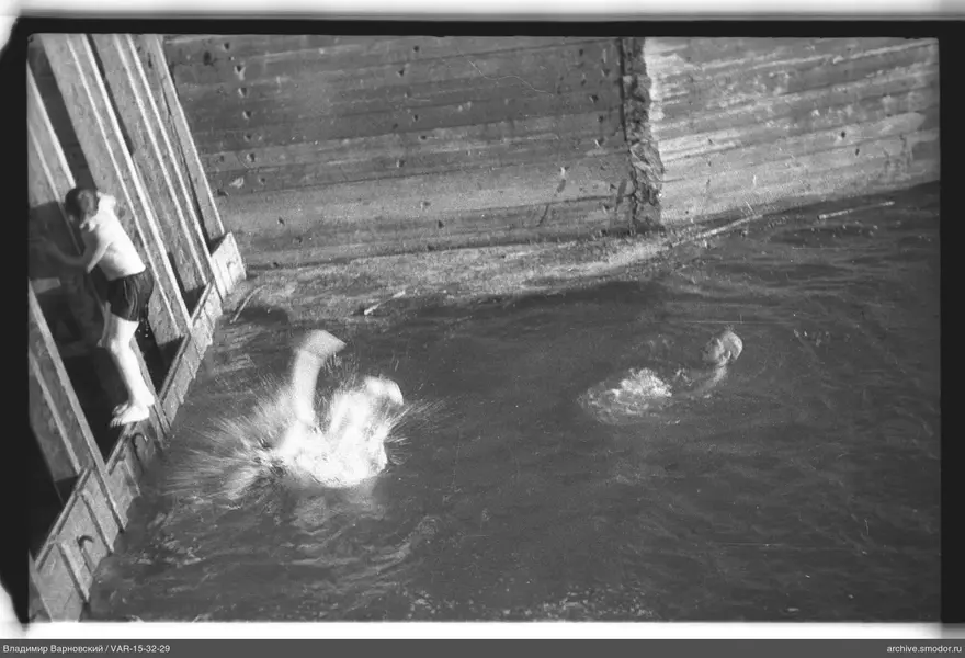 Drei Jungen im Wasser an einer Betonwand