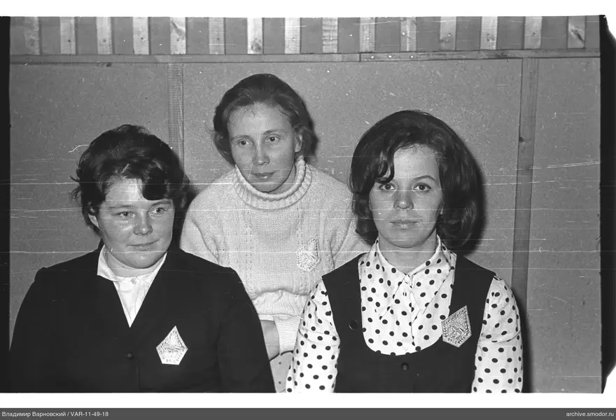 Gruppenporträt von drei Frauen vor Holzpaneelwand