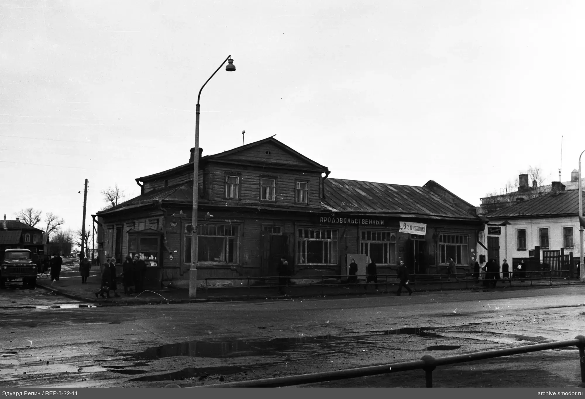 Holzgebäude mit Schildern und Straßenszene