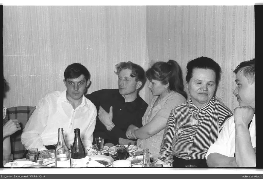 Group sitting at a table with dishes and bottles