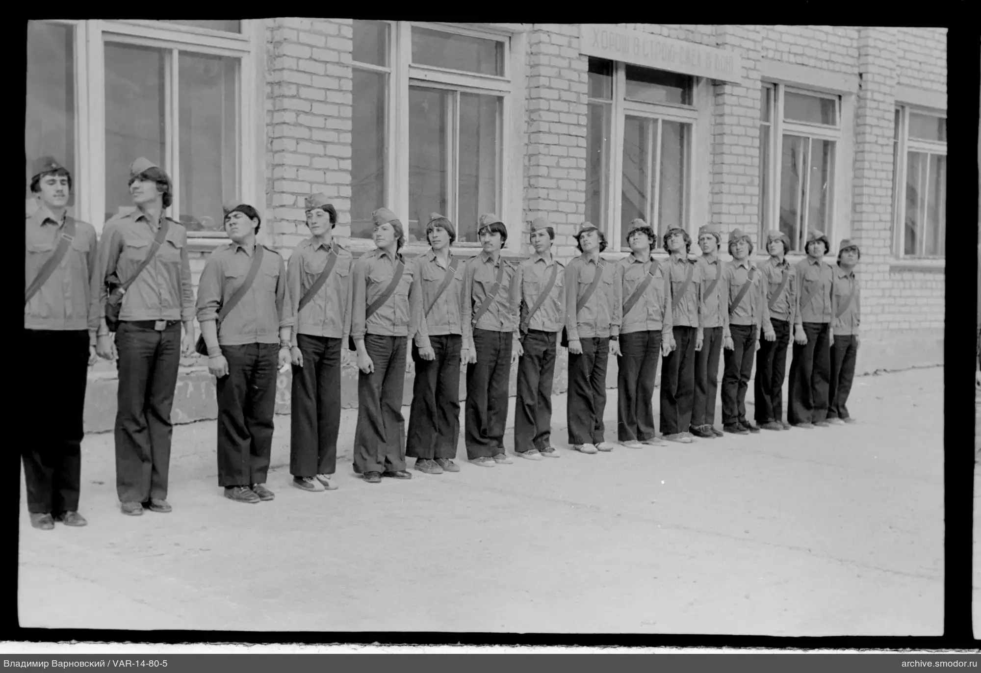 Group of people in uniform near brick building