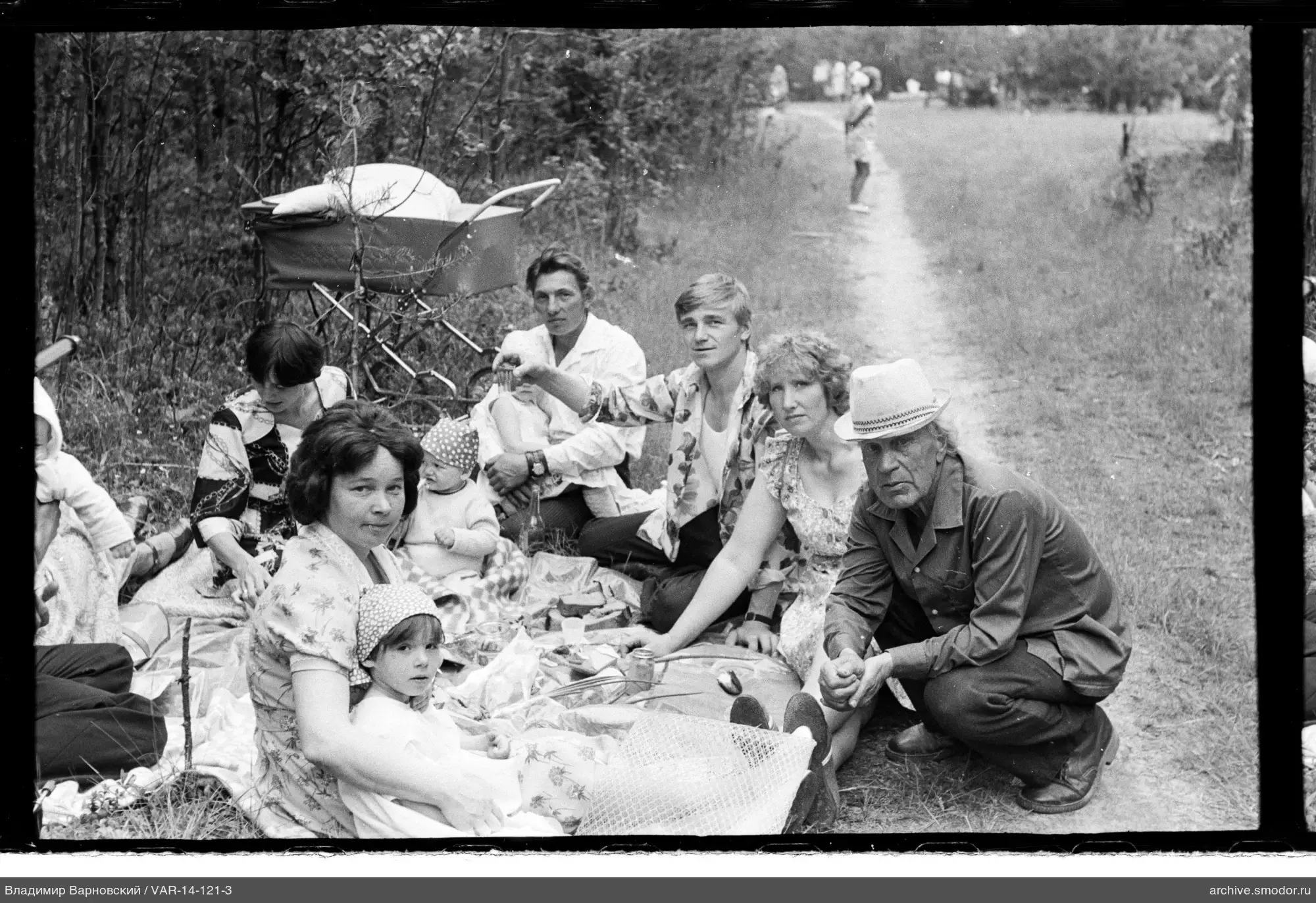 Group of people on grass near forest path