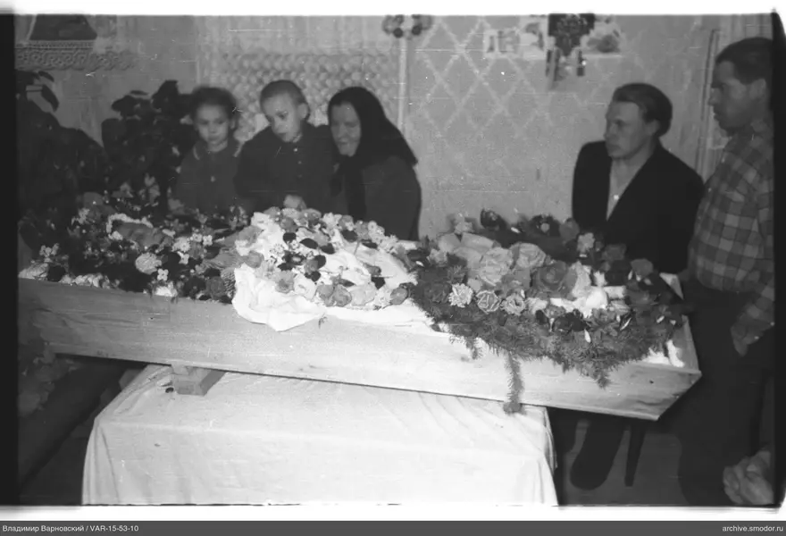 Деревянный гроб с цветами и венками