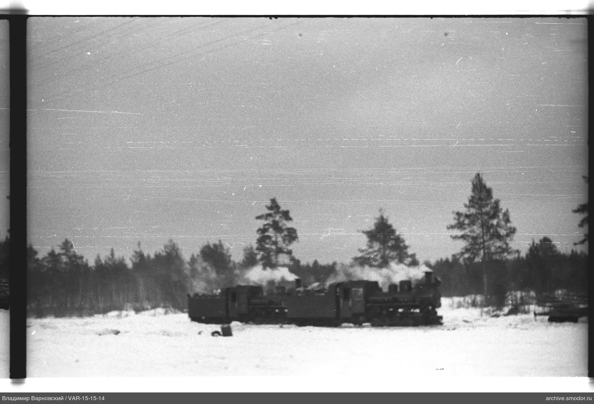 Dampflokomotive mit Güterwagen auf verschneiter Ebene