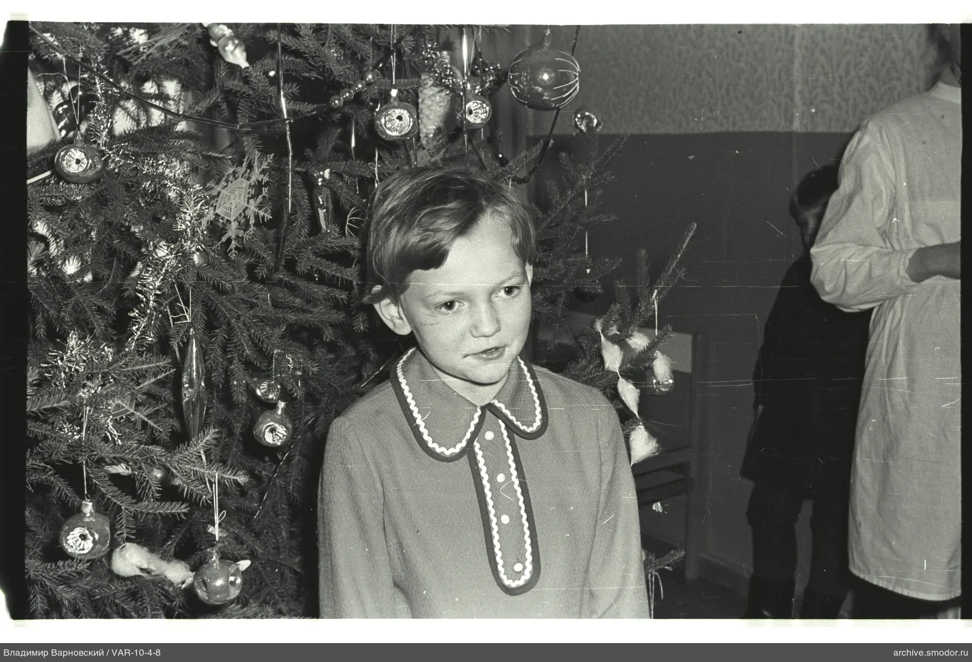 Porträt eines Kindes vor geschmücktem Weihnachtsbaum
