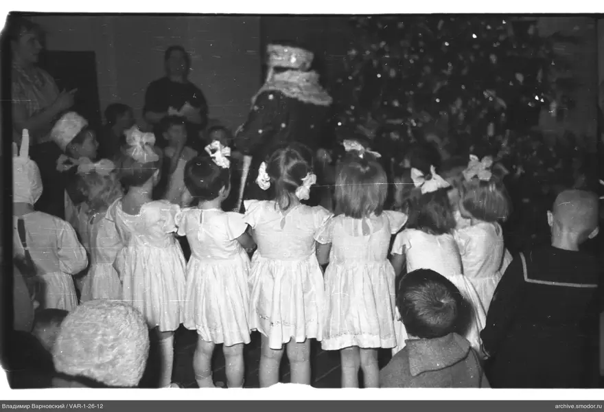 Kinder vor geschmücktem Weihnachtsbaum