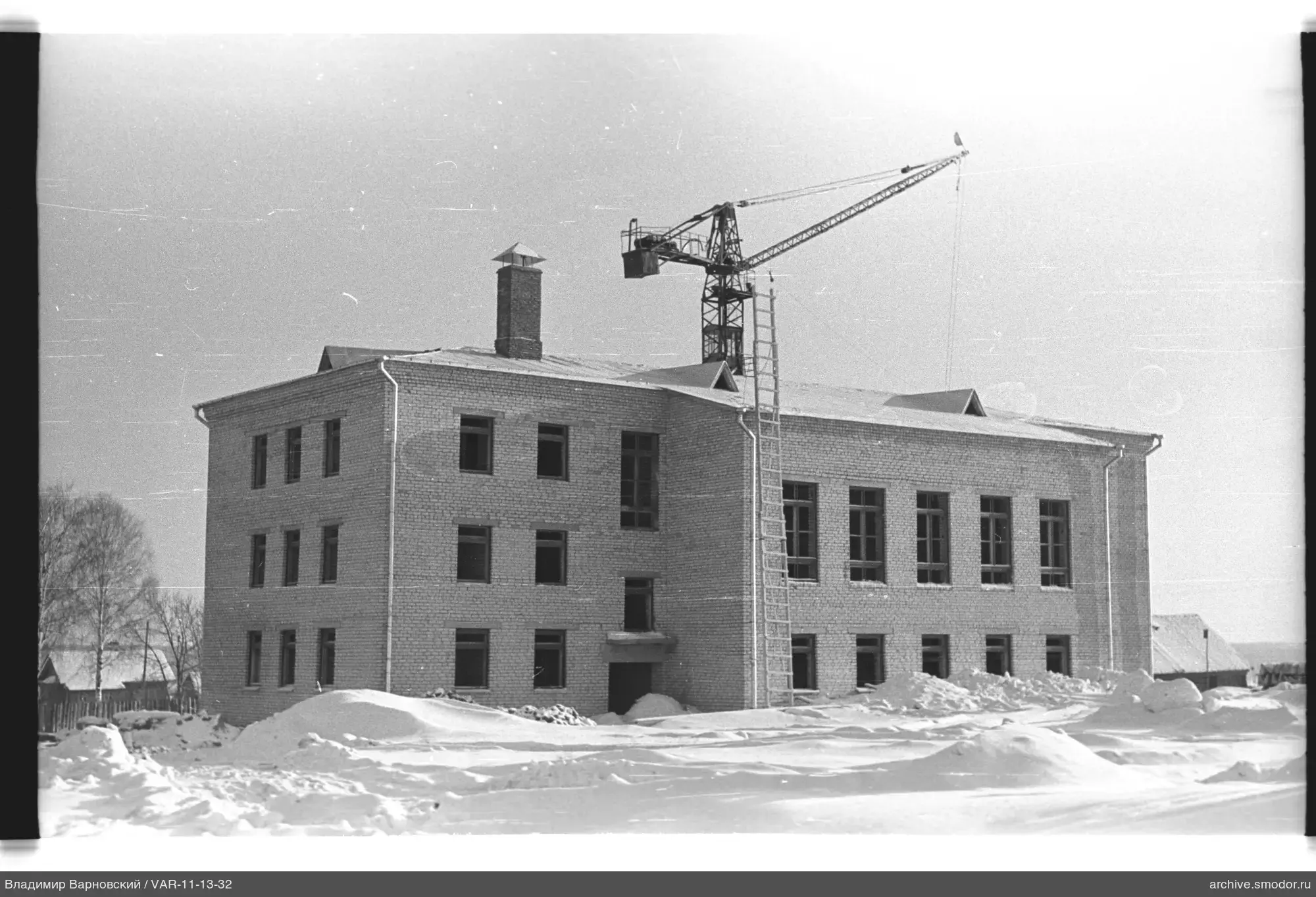 Backsteingebäude mit Turmkran und Schnee