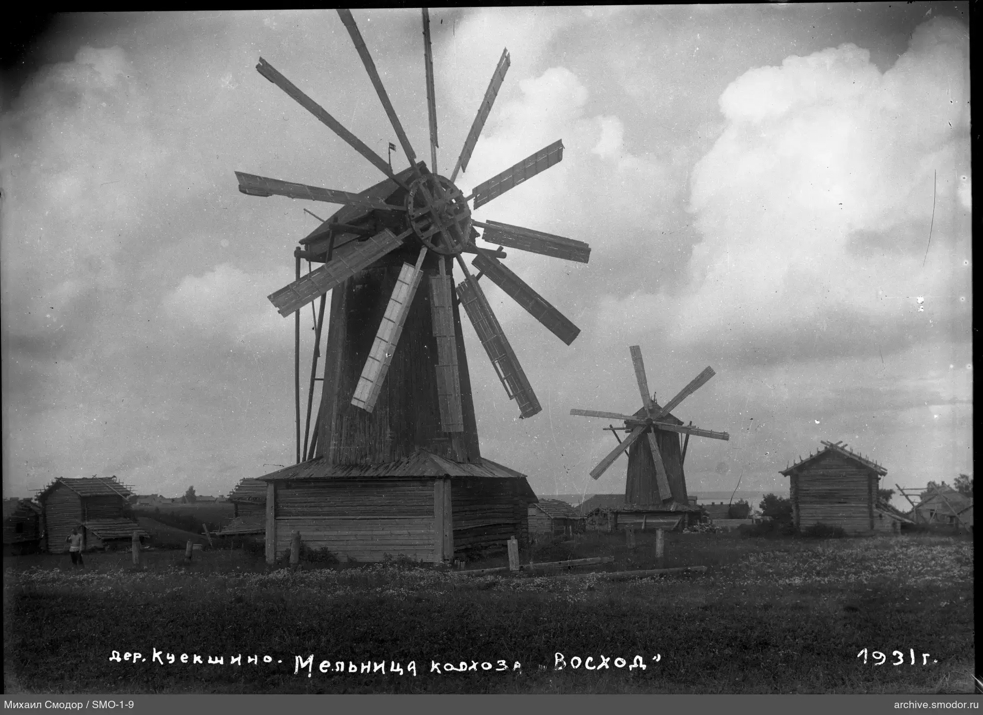 Zwei hölzerne Windmühlen im Feld