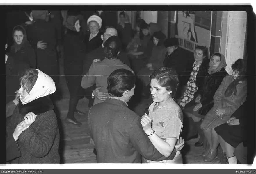 People dancing in a room with a wooden floor