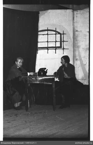 Two women sitting at a table with a teapot