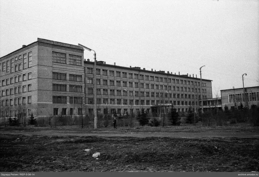 Многоэтажное здание с деревьями и человеком