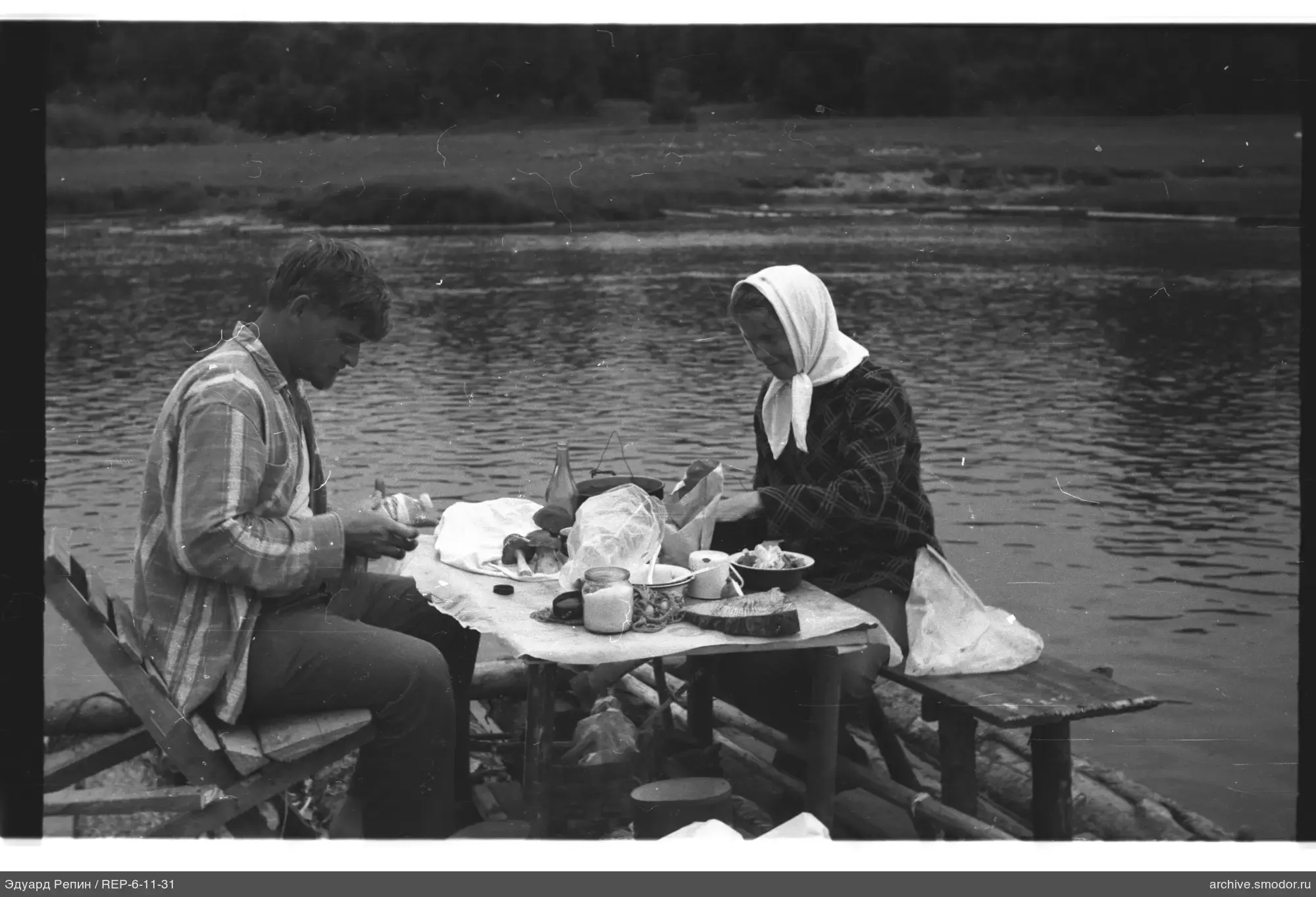 Man and woman sitting at a table by the water