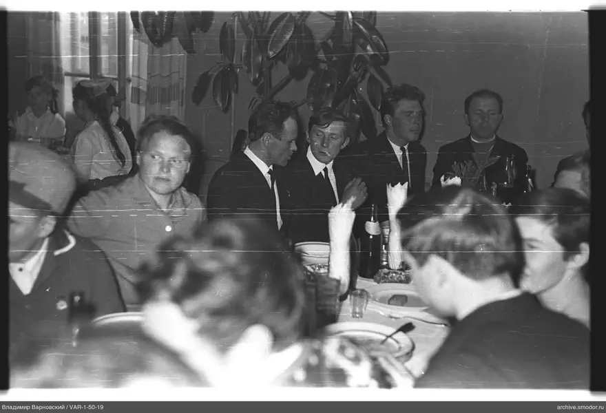 Group of people at a table with dishes and plant