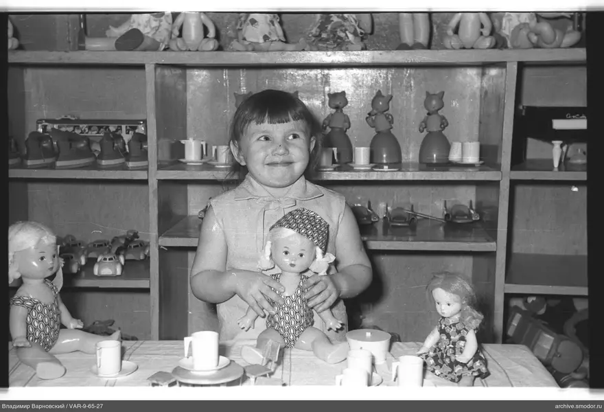 Mädchen mit Puppe am Spieltisch