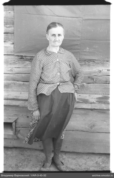 Woman standing by a wooden wall