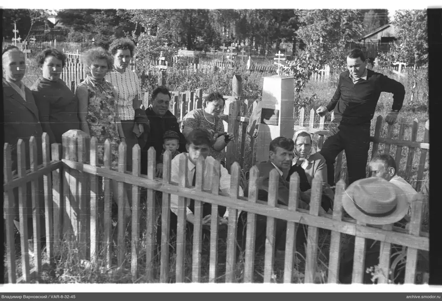 Gruppe von Menschen vor Friedhofszaun