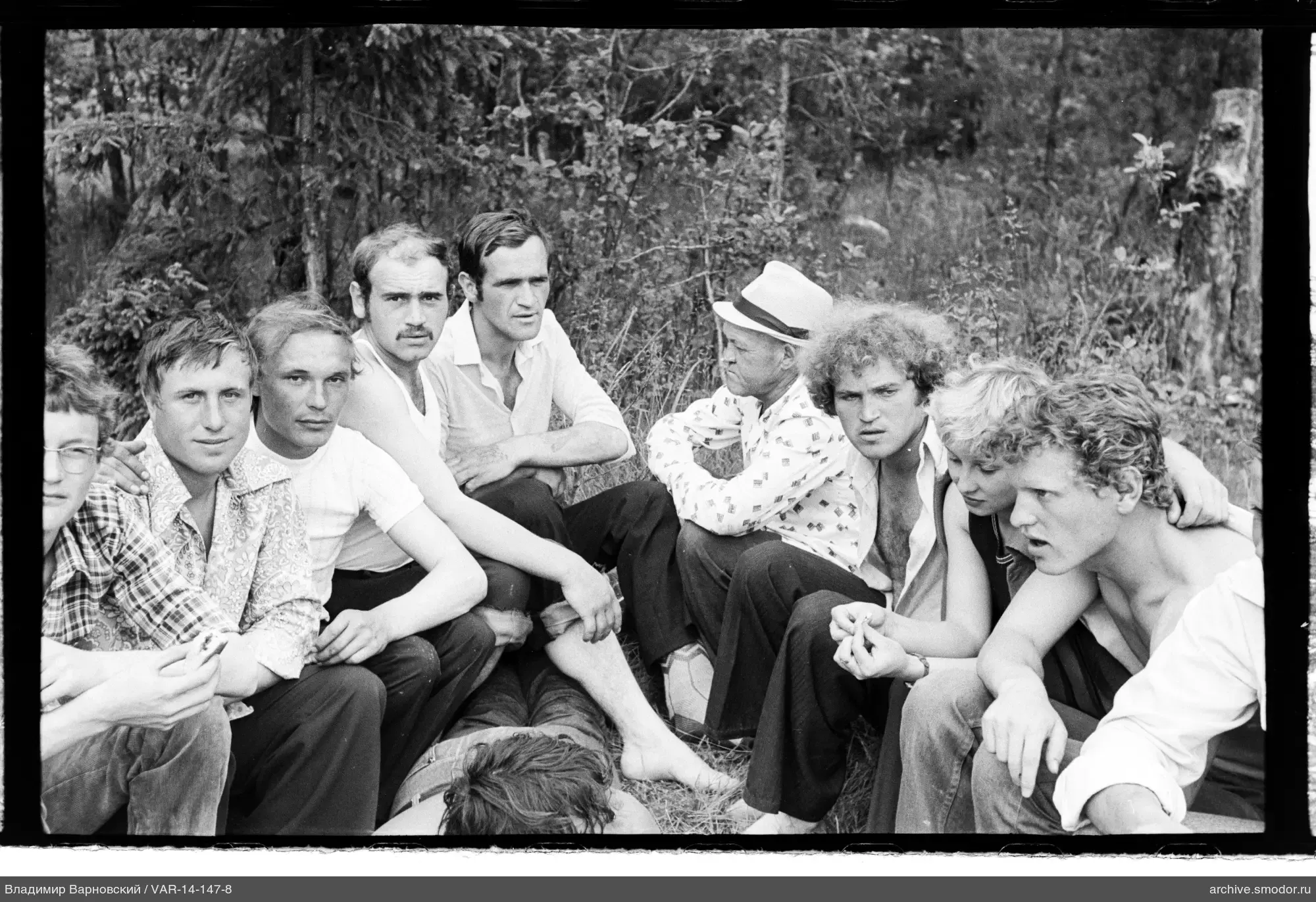 Group of people sitting on grass in forest