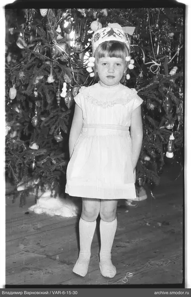 Mädchen vor geschmücktem Weihnachtsbaum