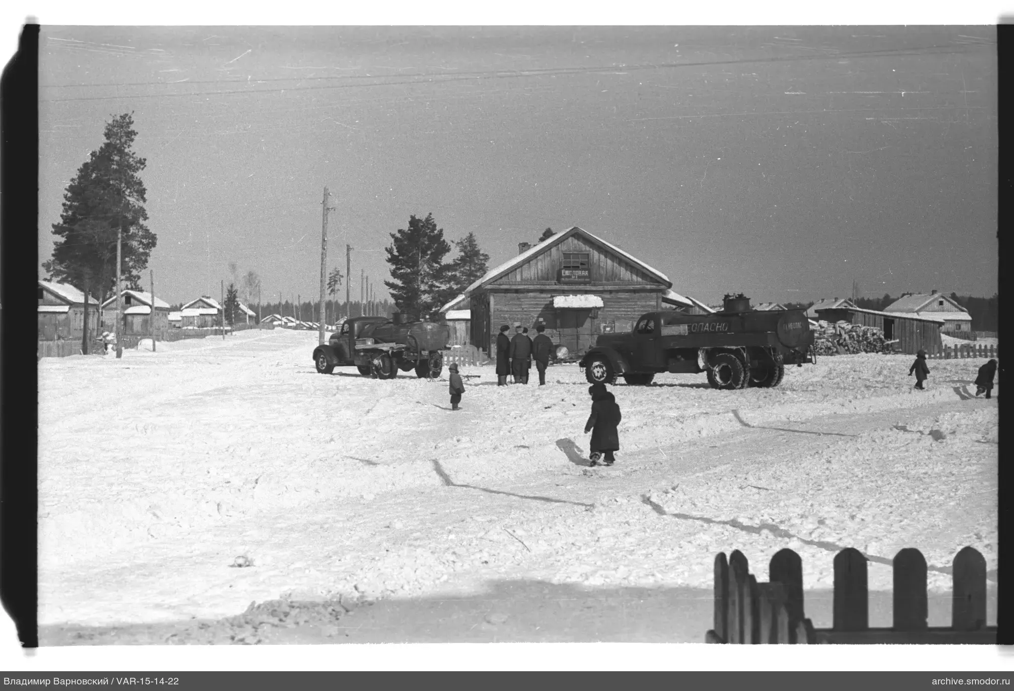 Lastwagen und Gruppe vor Holzgebäude