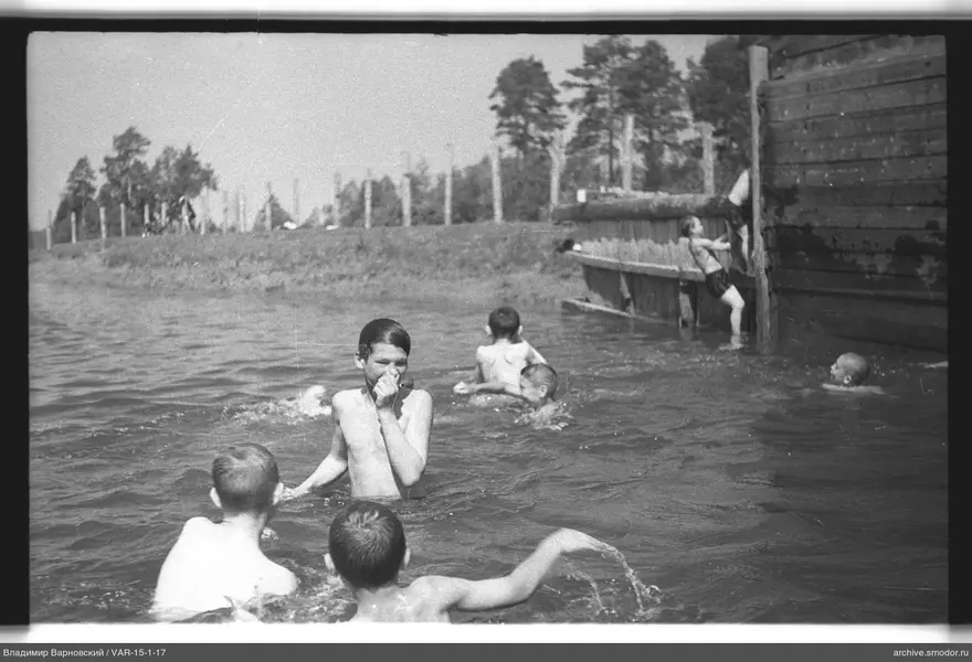 Jungen beim Baden an einem hölzernen Ufer