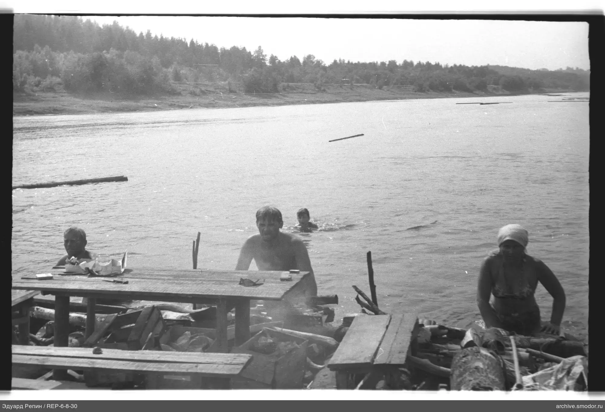 People in water near a wooden pier