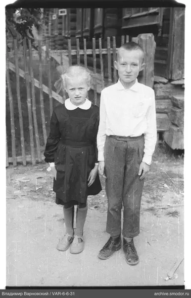 Kinder vor Zaun und Haus