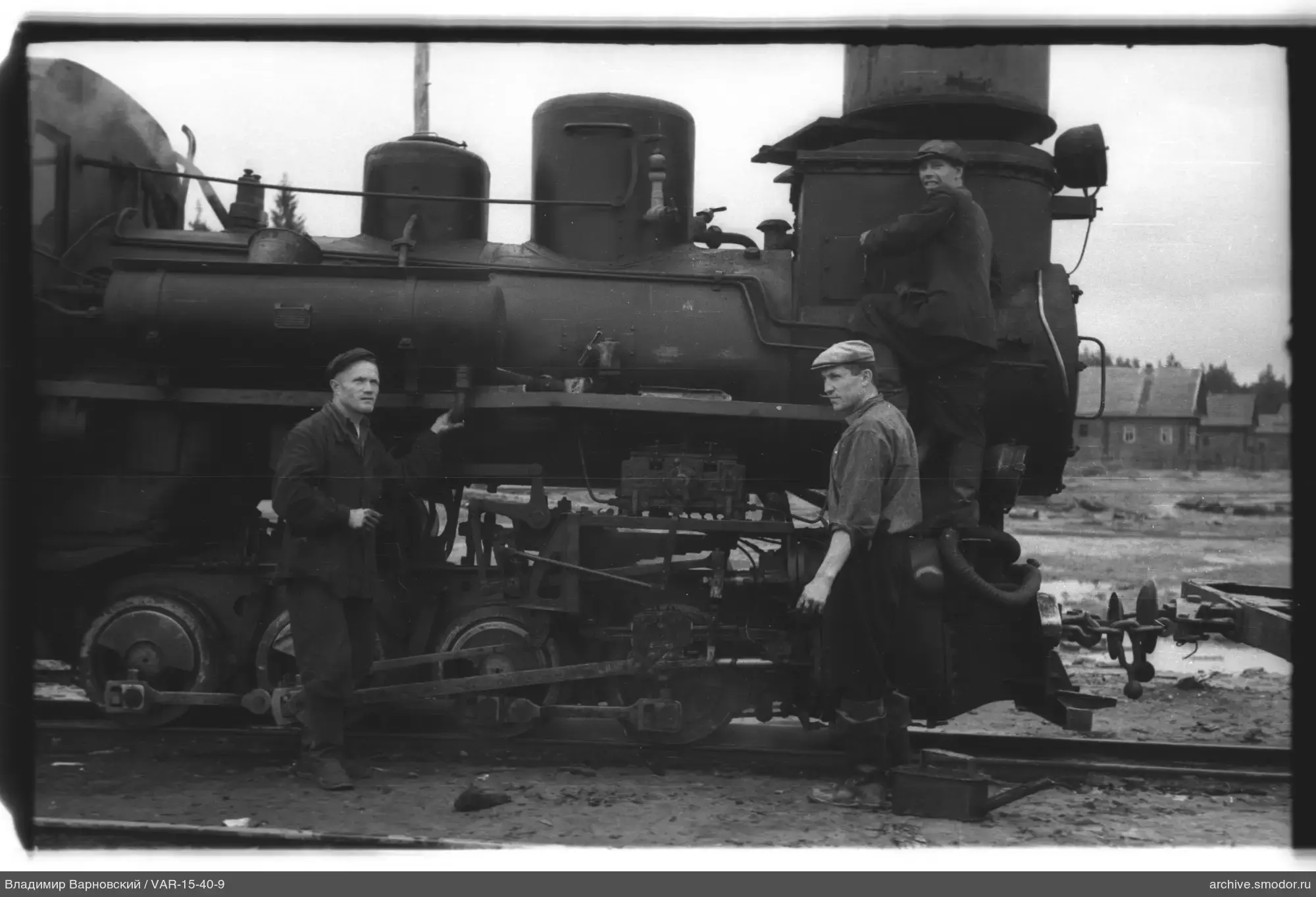 Three men by a steam locomotive