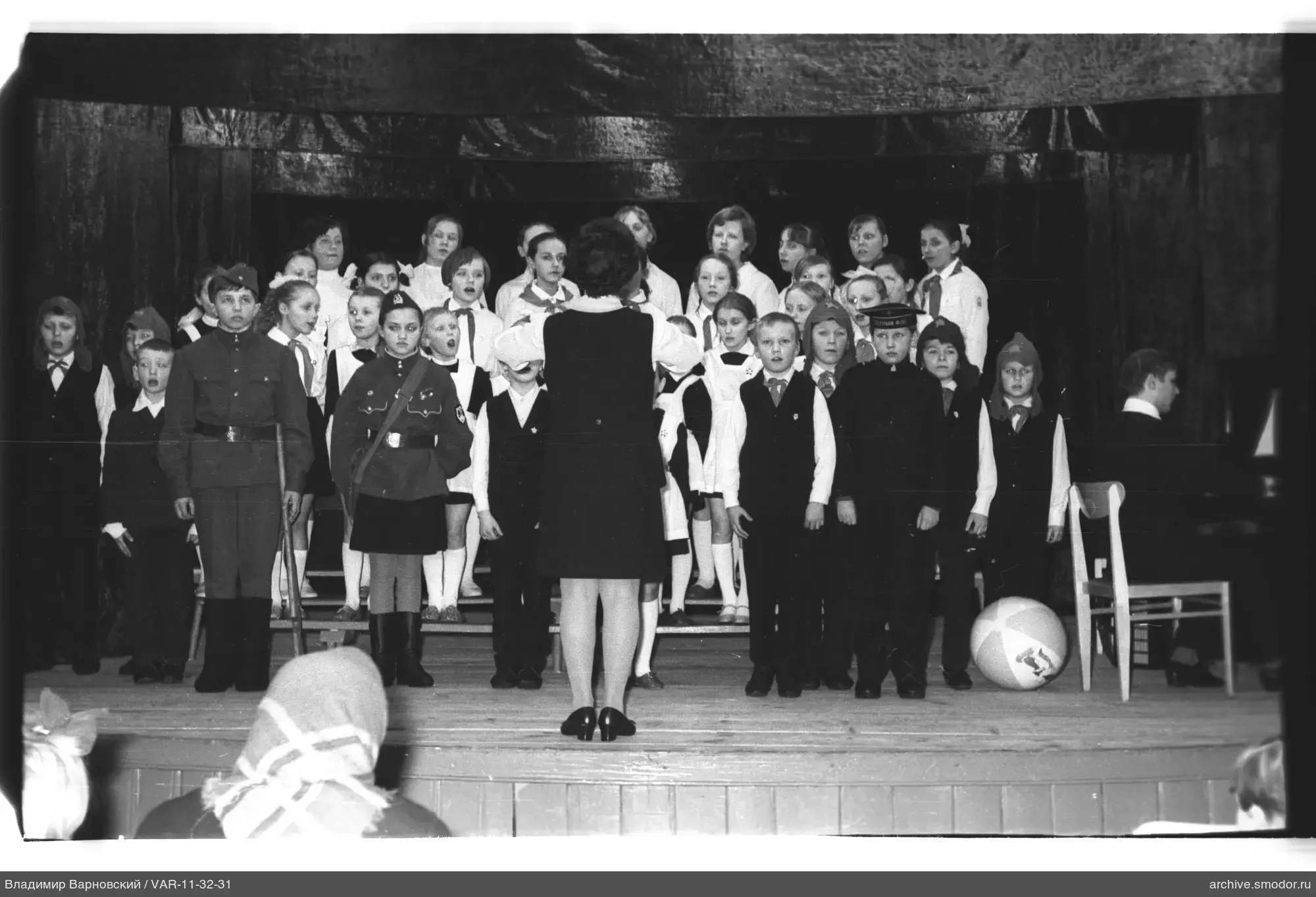 Kinderchor mit Dirigentin auf der Bühne