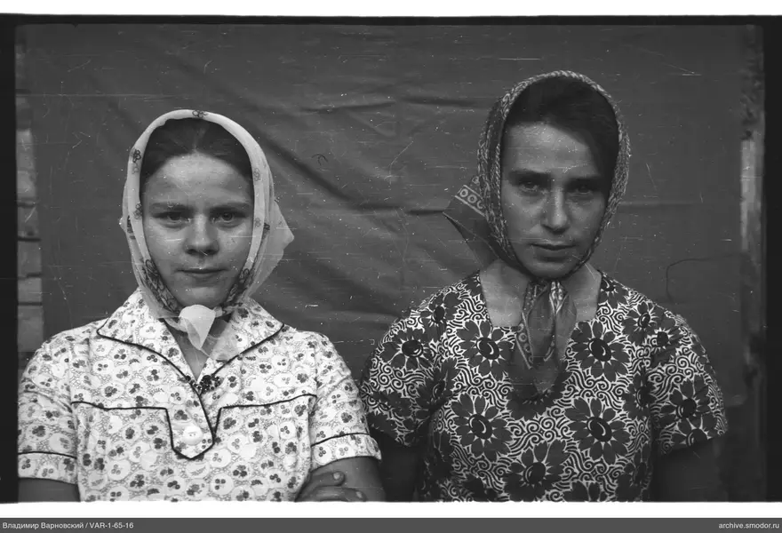 Two women with headscarves against fabric background