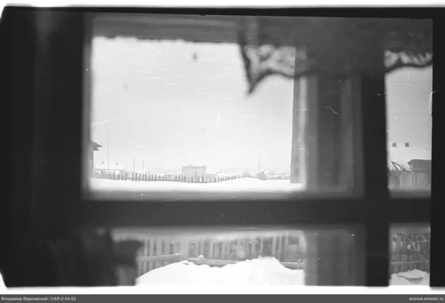 Blick durch das Fenster auf Schnee und Häuser