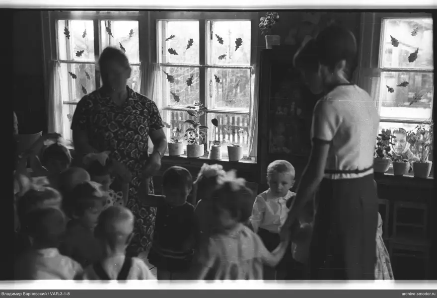 Kinder und Frauen bei großen Fenstern