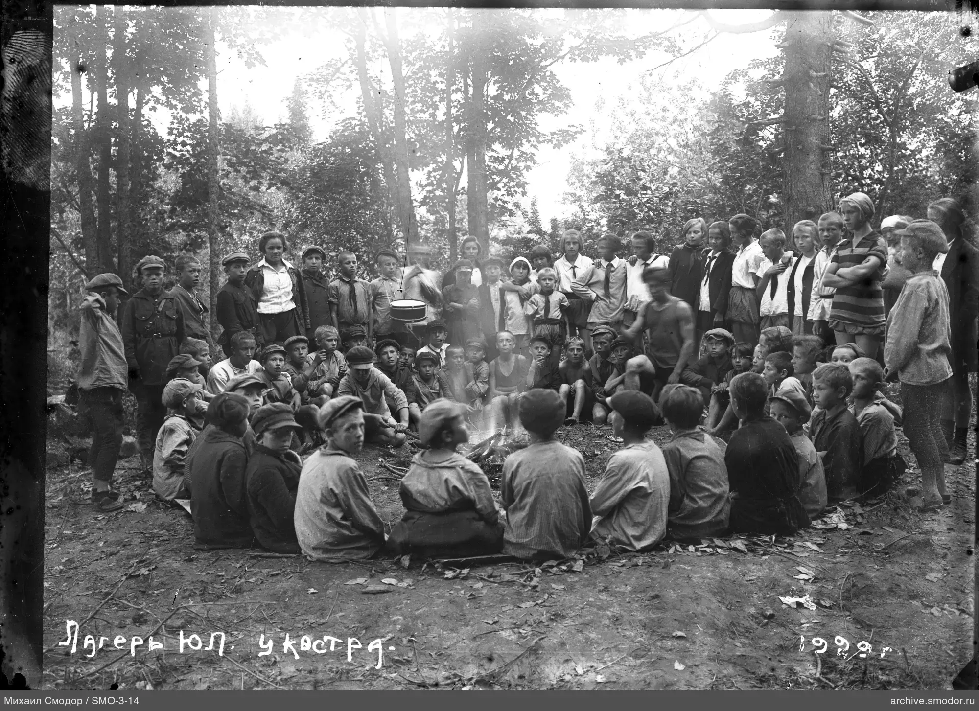 Gruppe von Kindern und Jugendlichen am Lagerfeuer