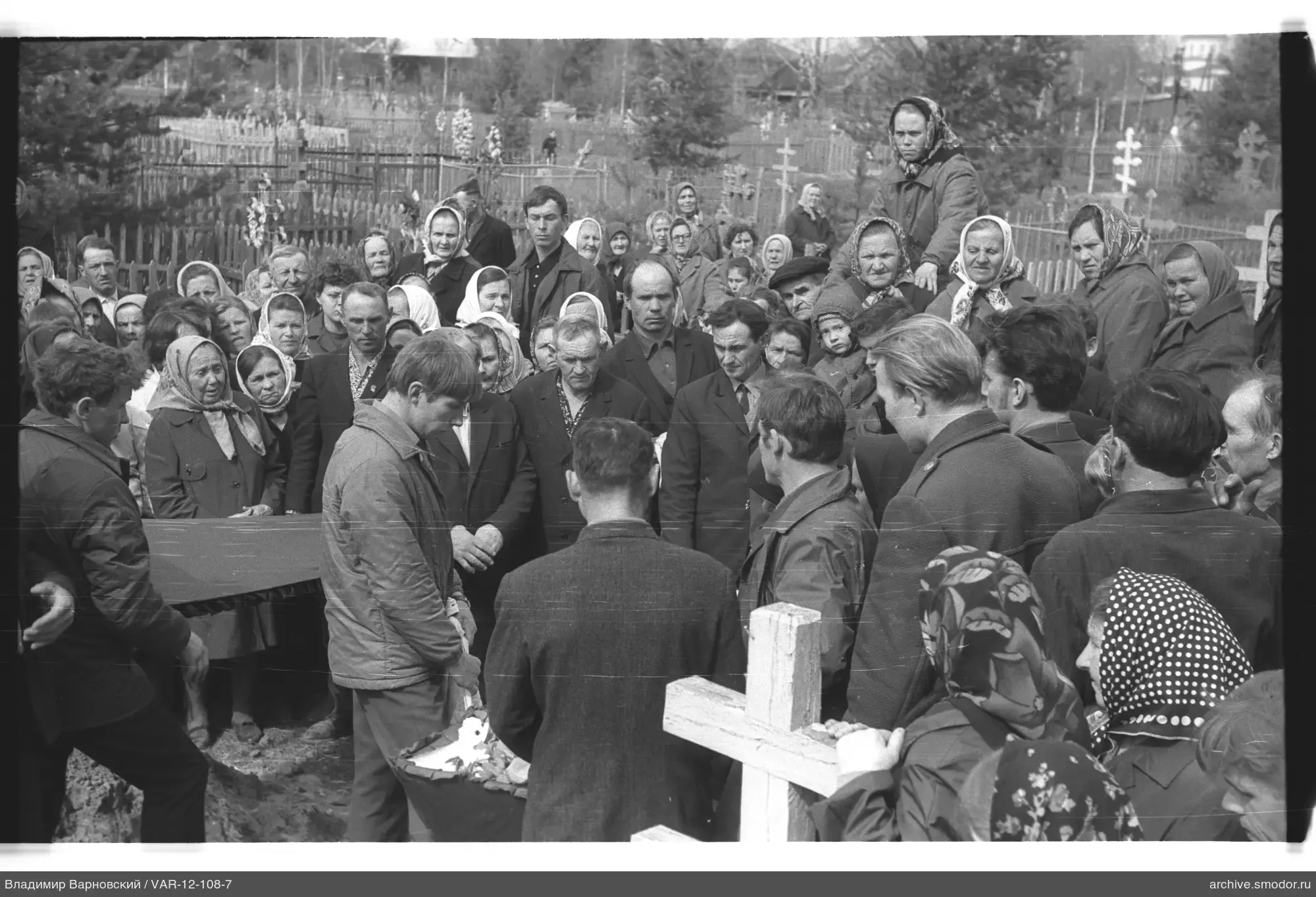 Gruppe um ein Grab auf einem Friedhof