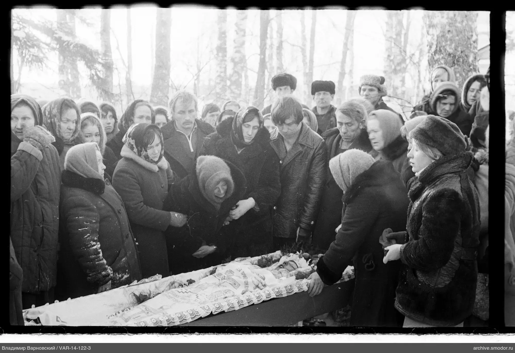 People around an open coffin