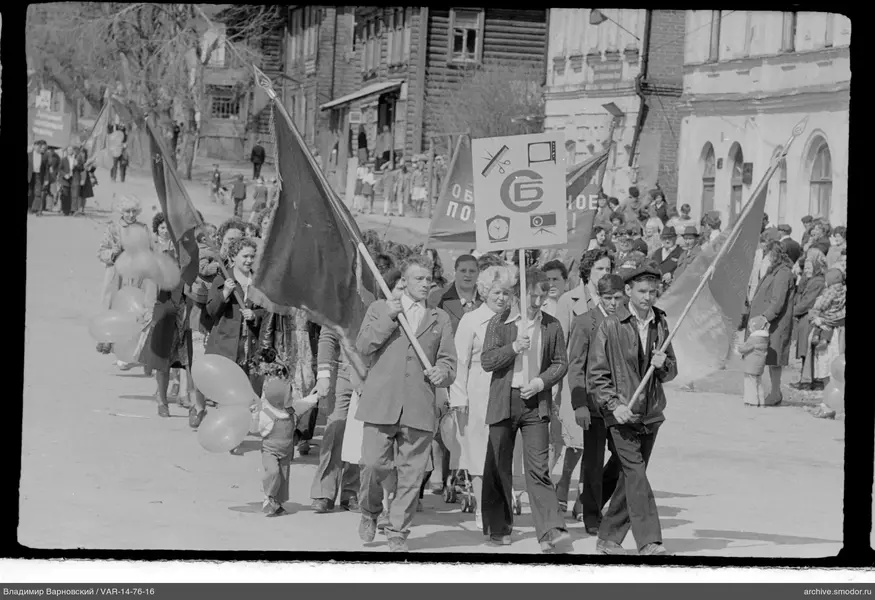 Gruppe von Menschen mit Fahnen und Plakat auf Straße