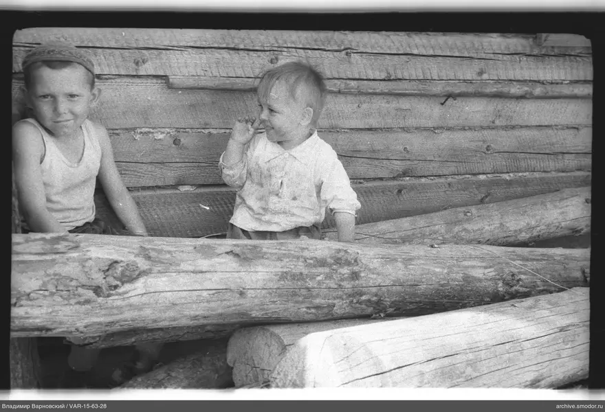 Zwei Jungen vor einer Holzwand