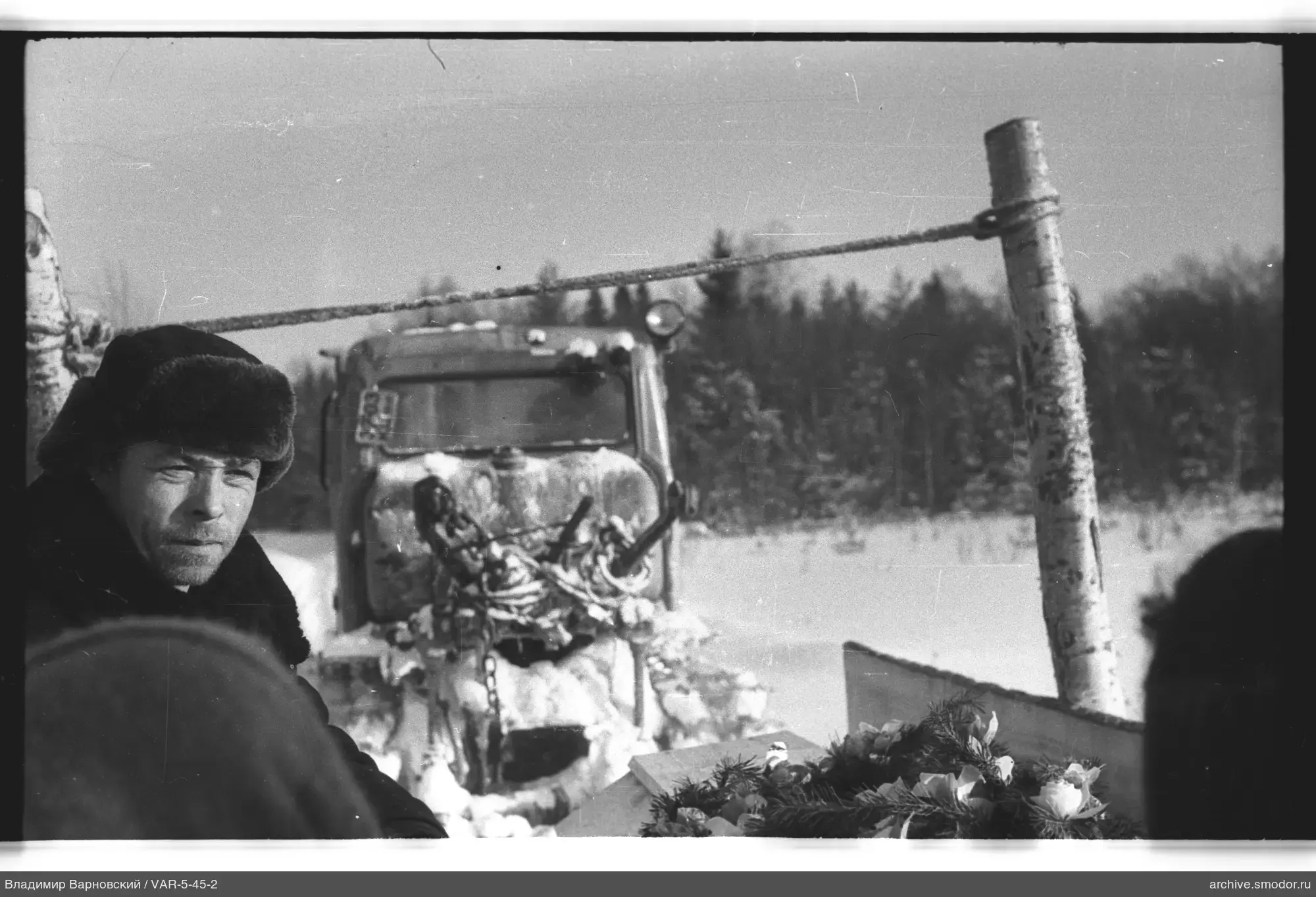 Mann bei Traktor im Schnee