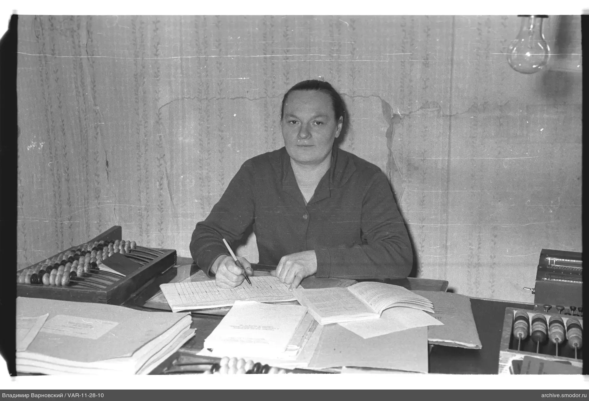 Женщина за письмом с книгами и счётами