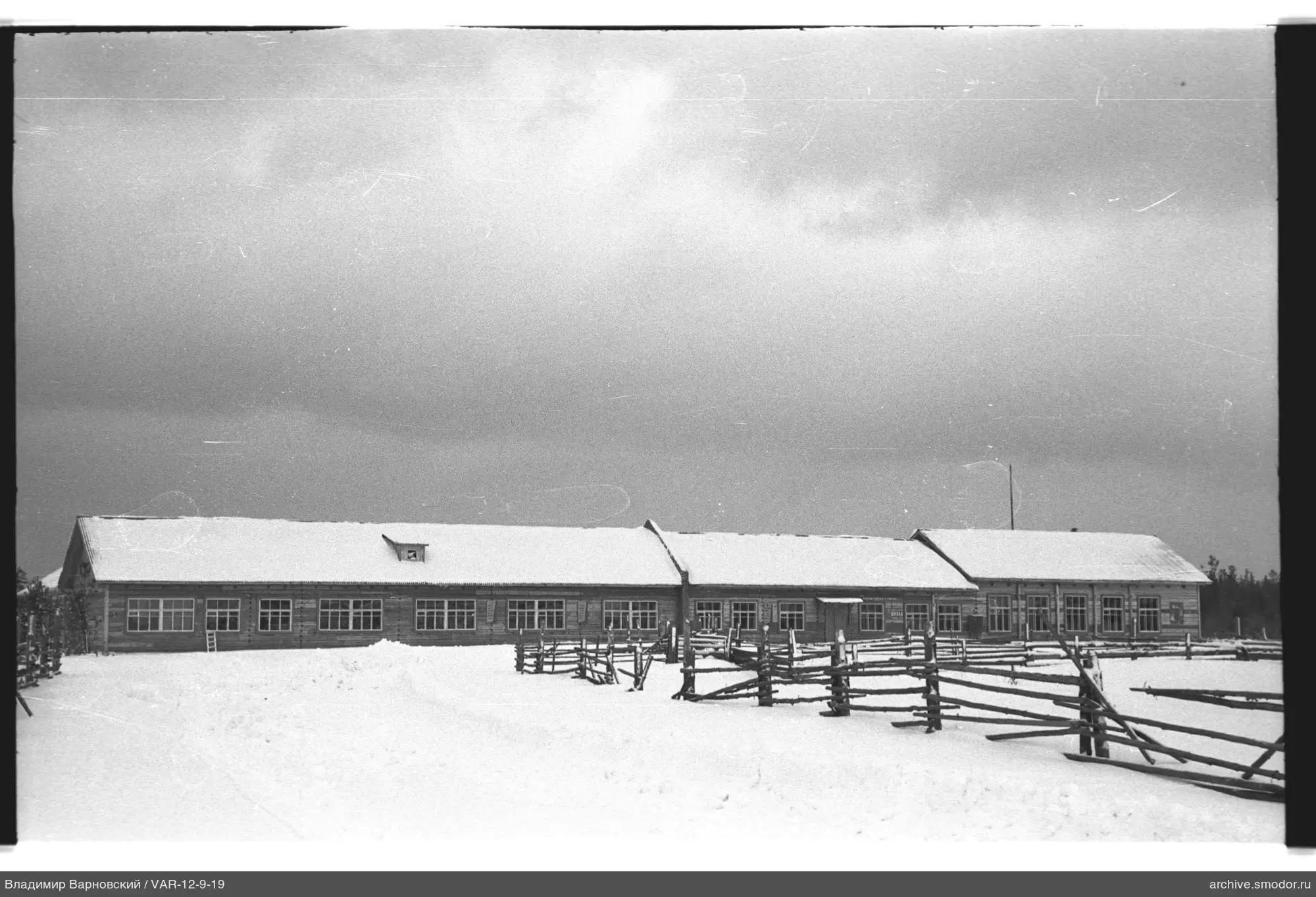 Langes Holzgebäude mit Schnee