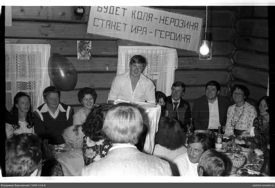 Menschen um einen Tisch im Holzraum