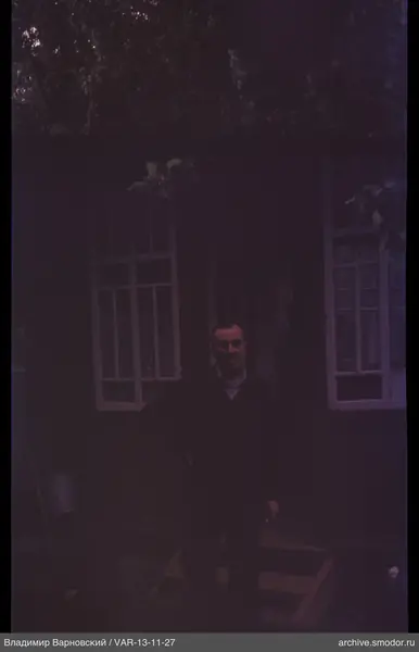 Man on the porch of a wooden house