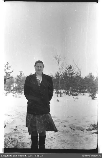 Frau im Schnee in dunklem Mantel