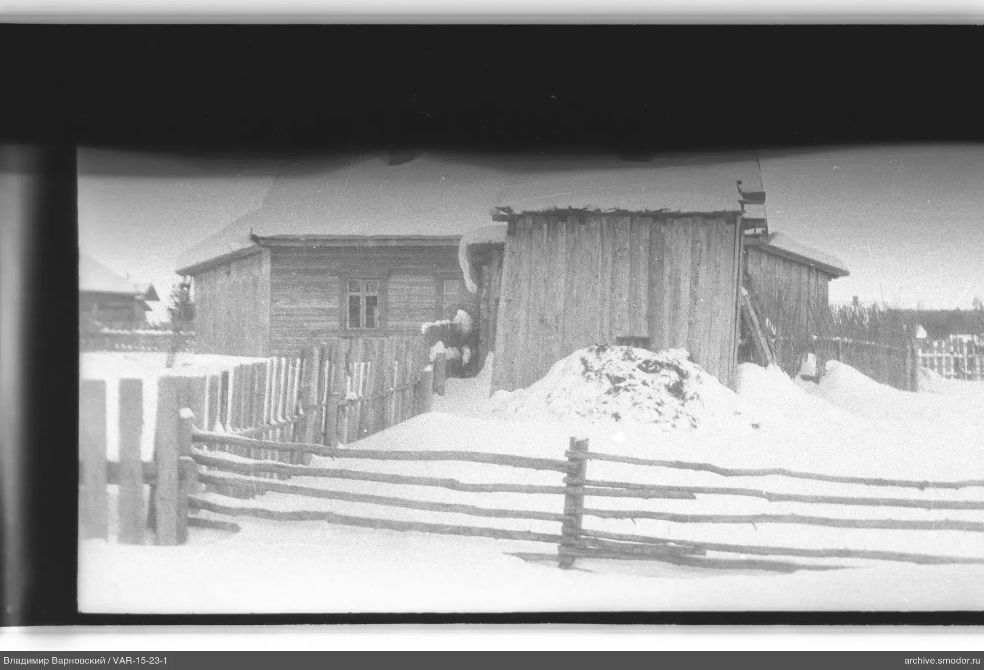Holzgebäude und Zäune im Schnee