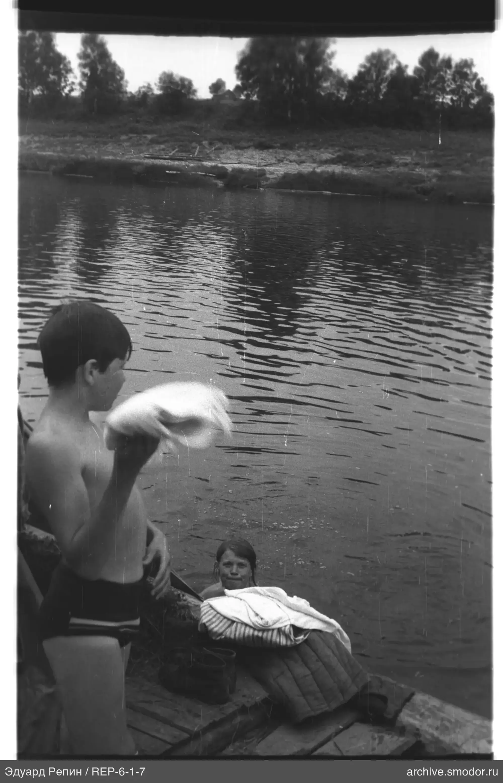 Junge und Mädchen am Wasser am Ufer