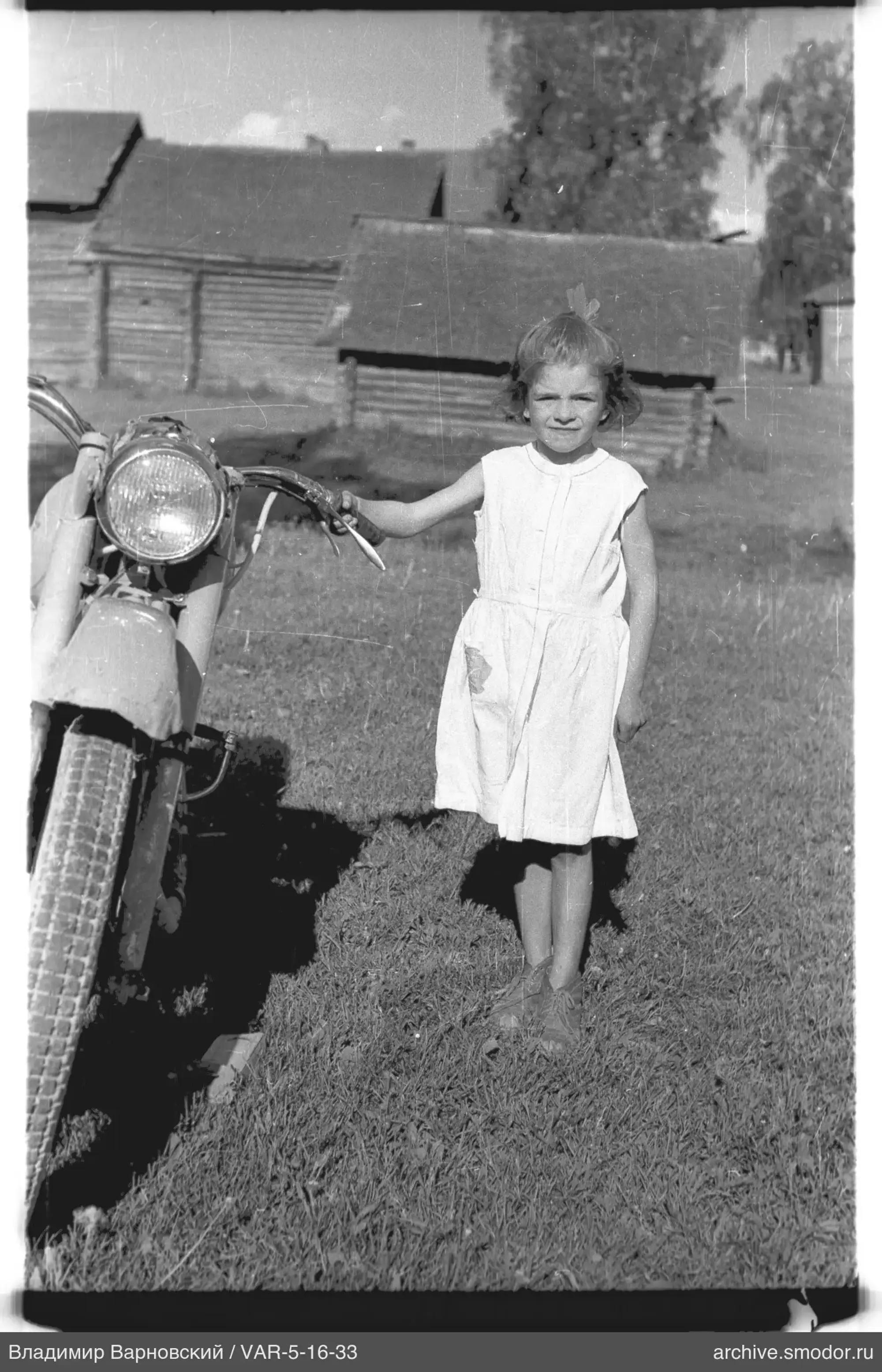 Kind mit Motorrad im Gras